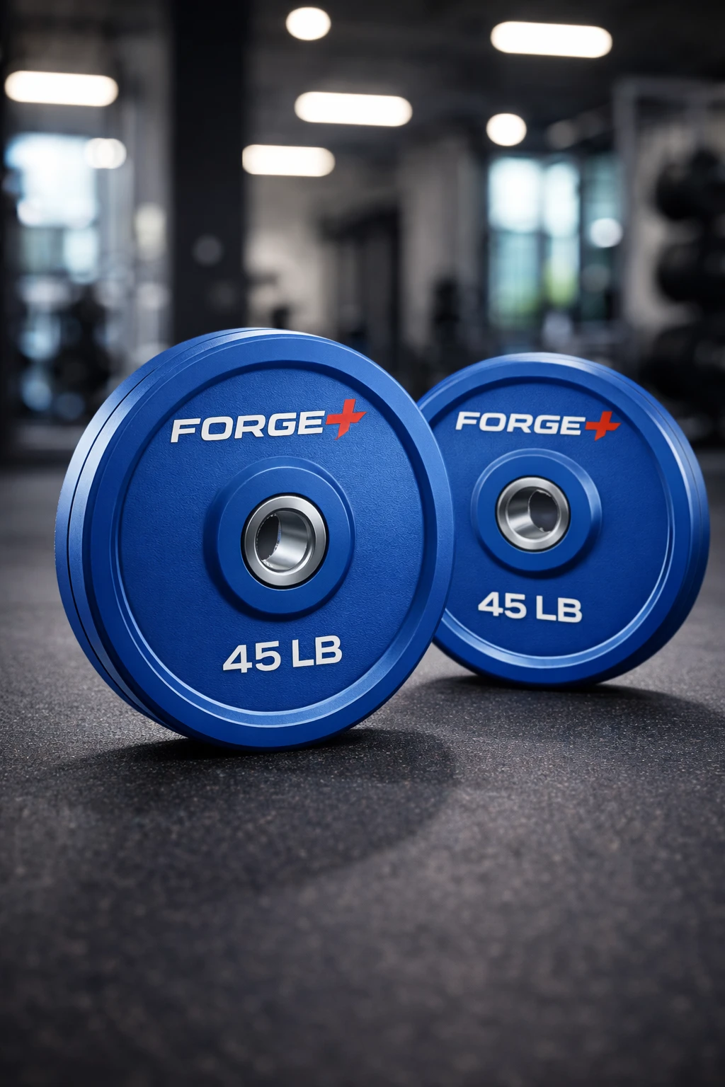 Blue Forge 45 lb weight plates on a gym floor with blurred equipment in the background for accessibility.